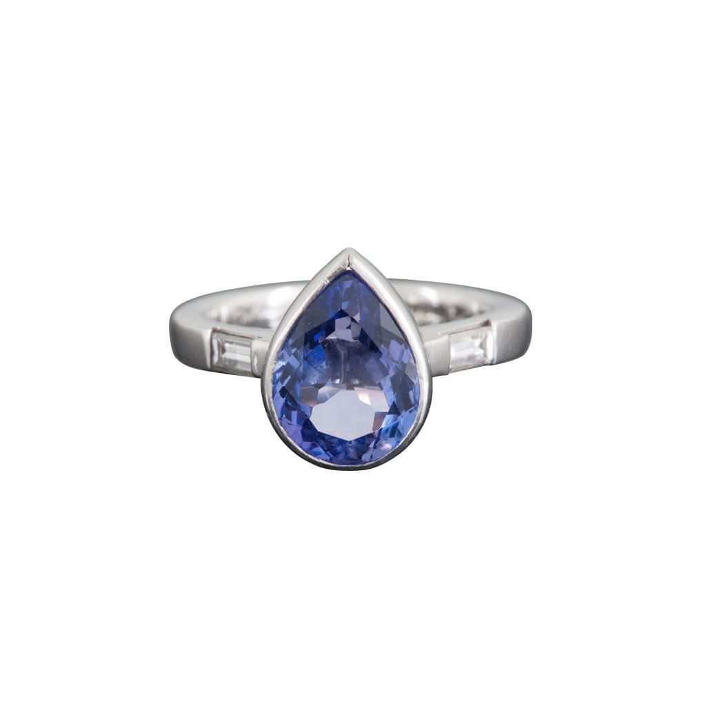 Ogden of Harrogate Jewellery A platinum and collet-set pear shaped tanzanite ring with baguette diamond-set shoulders